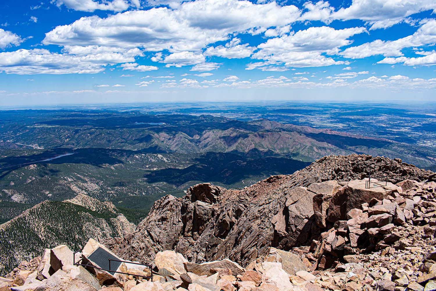 View from Pikes Peak overlooking layered mountain ranges under clear blue skies — a visual metaphor for focus and perspective